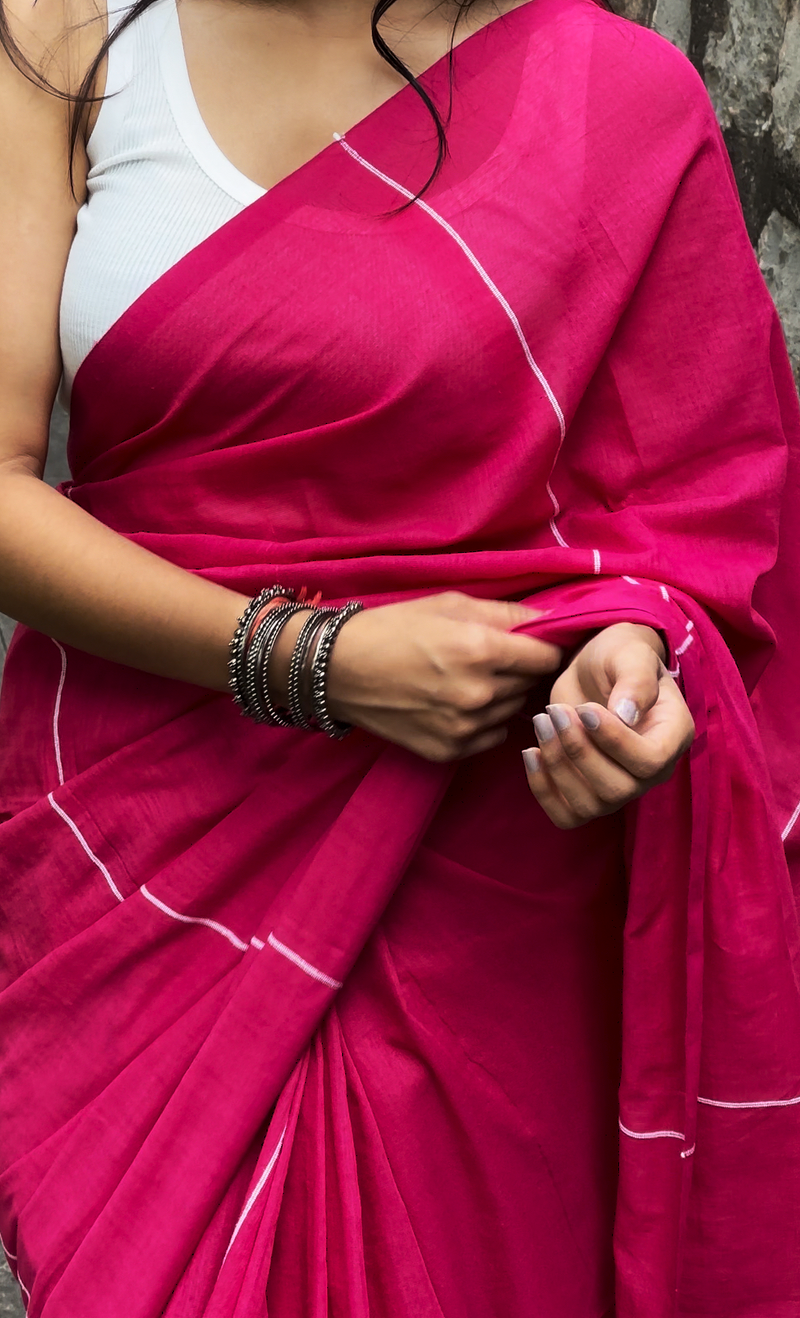 Close-up of a bright pink traditional saree with silver accents. This elegant saree is a perfect choice for those looking to buy a high-quality saree online for festive occasions.