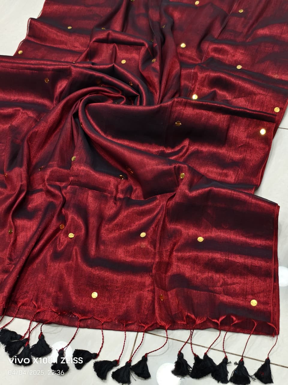 Maroon handloom saree with shimmering copper effect and golden  work and black tassels listed to order saree online.