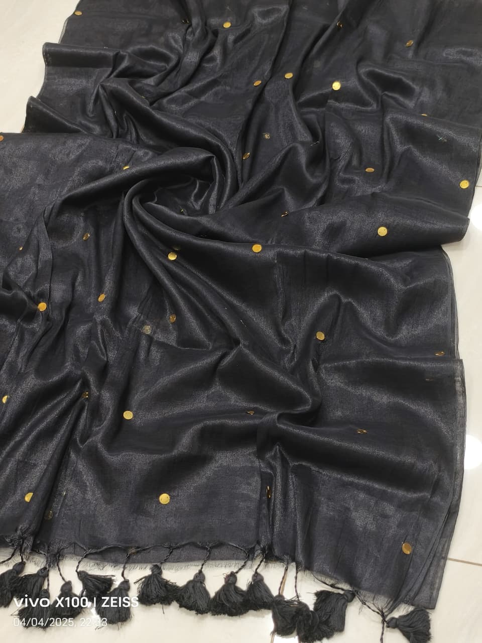 Black handloom saree with shimmering effect and golden work and black tassels listed to order saree online.