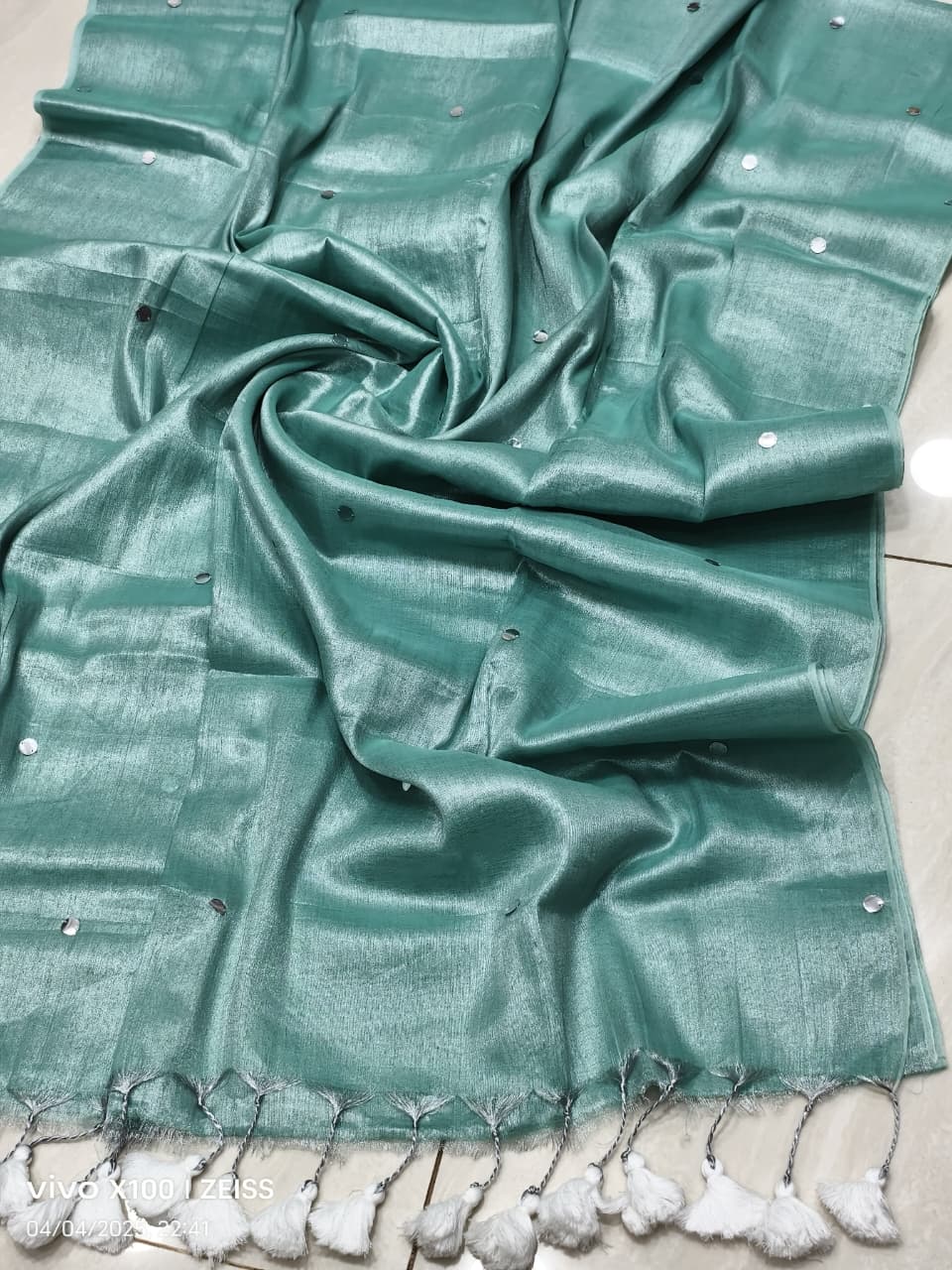 Mint aqua green handloom saree with shimmering effect and silver work and white tassels listed to order saree online.

