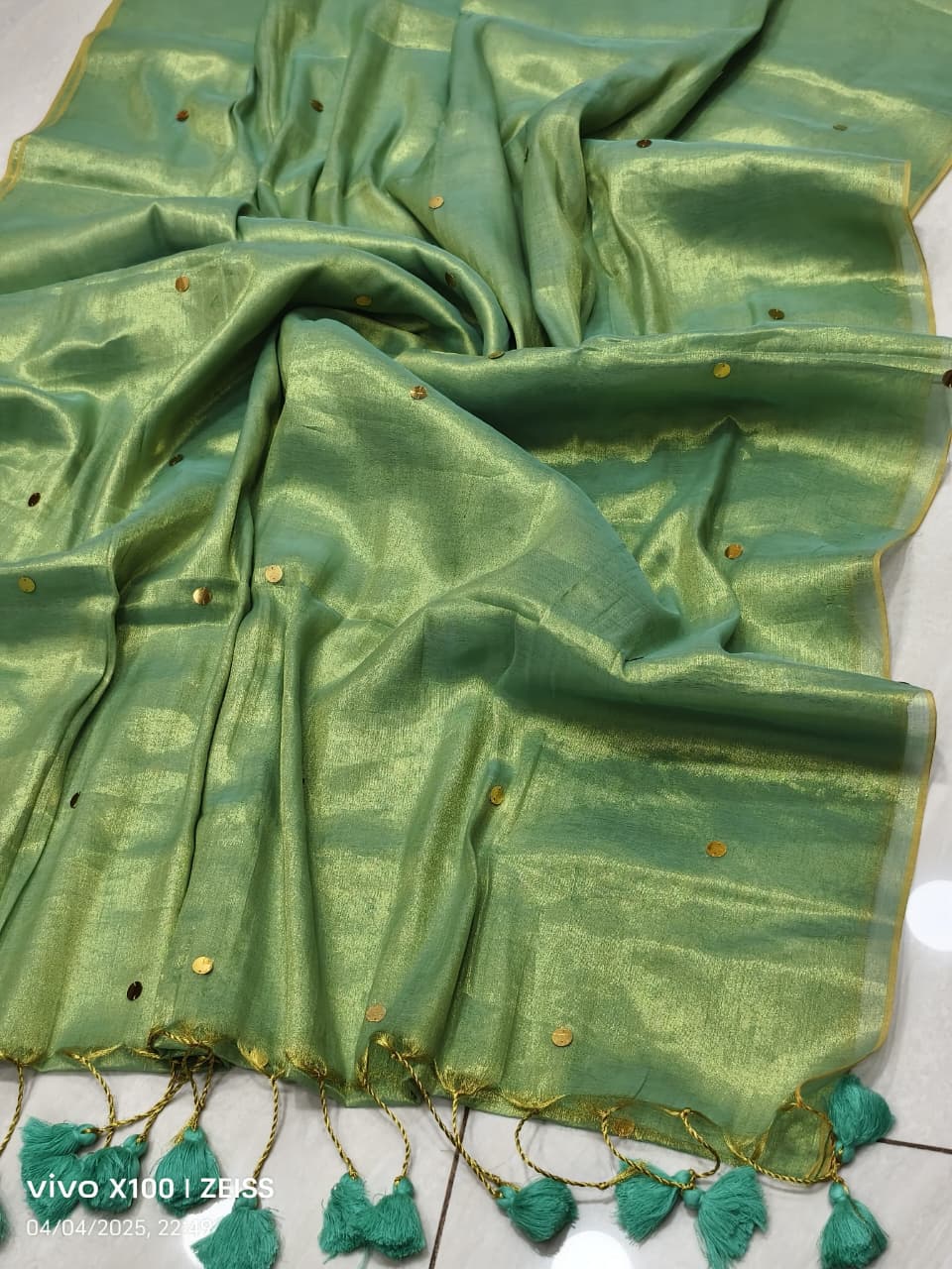 Olive green handloom saree with shimmering copper effect and golden  work and green tassels listed to order saree online.
