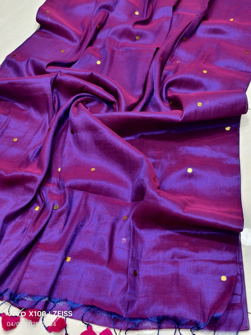 Purple and violet handloom saree with shimmering effect and gold work and pink tassels listed to order saree online.
