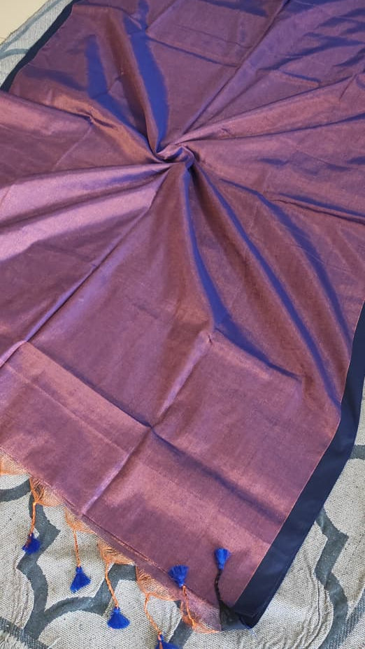 Zoomed picture of a Tissue silk handloom saree which is purple in colour with copper shimmer and blue tassels