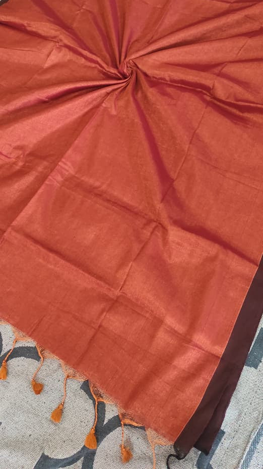 Tissue silk handloom saree which is red in colour with copper shimmer and pink tassels